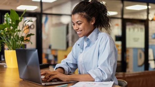 Side view smiley woman working with laptop office 23 2148908808