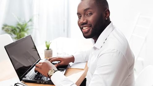 Portrait smiling african american businessman white shirt sitting happily looking camera while working his laptop office isolated 574295 3254